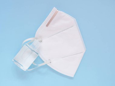 Mavi arka planda alkol jeli bulunan koruyucu yüz maskesi (N95), Tıbbi ve sağlık hizmetlerini, Üst Görünümü, Boşluğu Kopyala