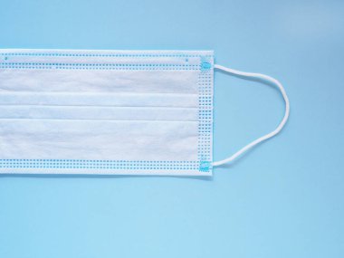 Mavi arka planda kirliliği ve virüsleri önlemek için tıbbi koruyucu yüz maskesi. Sağlık, Sağlık ve Yeni Normal Konsepti. Metnin için boşluk kopyala