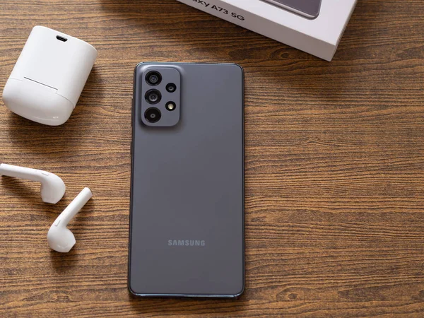 BANGKOK, THAILAND - 29 Eylül 2022: Yeni Samsung Galaksisi A serisi kamera 108 MP, ahşap işyeri arka planında gri renk