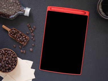 Üst manzara, düz tablet tablet ve bir top kahve çekirdeği, şişe, siyah masa derisine kase. Kafe menüsü için kavram