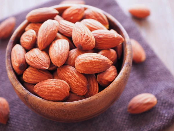 stock image Organic almonds seed in wooden bowl on sackcloth. Colse up. Healthy food