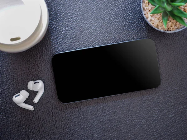 Top view, blank black screen of smartphone and wireless earphone in-ear with charging case on black leather background. Template, mock-up empty screen of mobile phone for text and logo of product