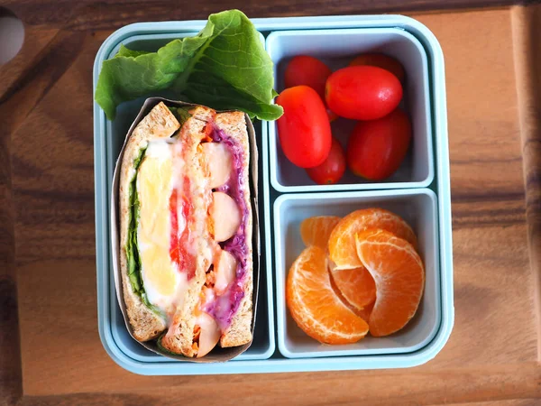 파란색 도시락 샌드위치와 오렌지 토마토 야채를 배경에 넣습니다 위에서 로열티 프리 스톡 이미지