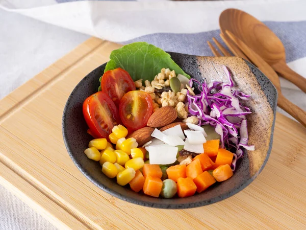 Healthy food and  weight loss concept. Homemade mixed salad, almond in old clay bowl on cutting board.