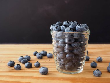 Yaban mersinli antioksidan organik, cam bardakta, tahtanın üzerinde. Kopya alanı ile yakın çekim. Sağlıklı yeme ve beslenme konsepti