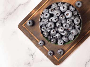 Organik olgun taze yaban mersinleri kesme tahtasında kasede. Sağlıklı yeme ve beslenme kavramı, Top view, metnin için düz alan. Süper yemek.