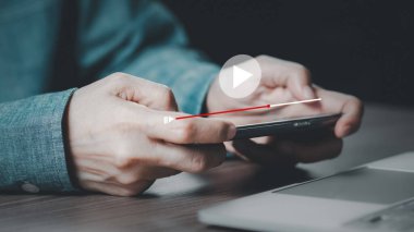 Adam internetten akıllı telefon izleme videosu kullanıyor, canlı ya da özel olarak sanal ekranda oynatma düğmesi ile çevrimiçi yayın yapıyor.