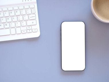 Üst manzara, fotokopi alanı olan düz bir yer. Açık mor ofis masasında akıllı telefon maketi, kahve fincanı ve klavye bilgisayarı. İnternet alışverişi, blog, logo, ürün ve sosyal medya kavramları.