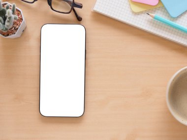 Cep telefonu boş. Kahve fincanı, kaktüs ve tahta kalemi olan bir model. Üst görünüm bileşimi. Konsept alışverişi, blog, logo, sosyal medya ve ürünü.   