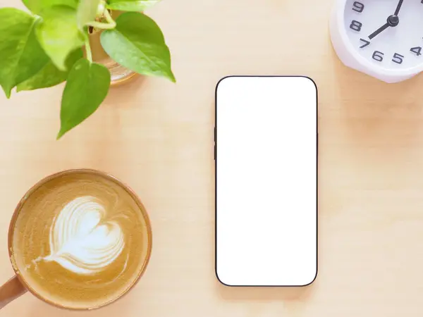 Düz, bembeyaz ekran akıllı telefon, kahve fincanı ve bitki, saat açık tahta arka plan. İnternet alışverişi, blog, logo, ürün ve sosyal medya kavramları.    