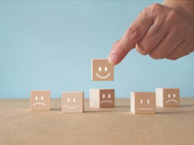 Müşteri hizmetleri mükemmel ve tatmin edici derecelendirme konsepti. Müşteriler gülen yüz bloğunu ya da kahverengi arka plandaki en iyi servisi seçiyor. Yüksek kaliteli ürün veya hizmet için reytingler