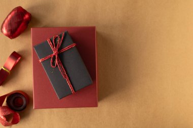 Üst manzara, kahverengi arka planda kırmızı bir iple bağlanmış siyah hediye kutusu. Kopya alanı olan tatil kavramı.