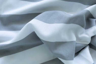 Gri ve beyaz tonlarda yumuşak, akışkan bir kumaş. Metnin ve tasarımın için uzayı kopyala. Tekstil konsepti ve yumuşak arkaplan, düz yatıyordu
