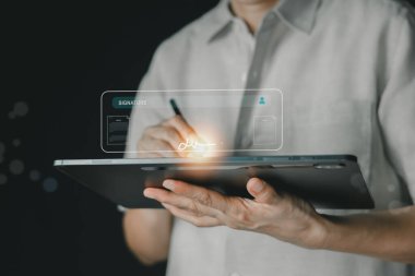 Bir tableti tutarken, dijital bir kalemle holografik bir arayüze imza atarken yakın plan. E-imza, çevrimiçi anlaşmalar ve güvenli dijital işlemlerin kolaylığı ve verimliliği