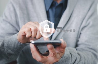 Businessman holding a smartphone, inputting a password for a secure login. A shield icon symbolizes cybersecurity, data protection, online privacy, and secure network access authentication