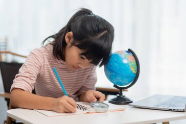 Asyalı küçük kız dünyayı kurtarma konseptini öğreniyor ve evde çocuk eğitimi için oyun aktivitesi yaparak öğreniyor..