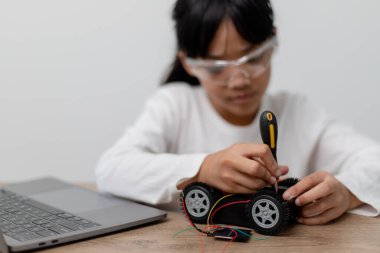 Asyalı öğrenciler evlerinde robot arabaları ve elektronik tahta kablolarını STEM, STEAM, matematik mühendisliği, bilim teknolojisi bilgisayar kodlarını çocuk konsepti için robotikte kodlayarak öğreniyorlar..