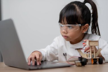 Asyalı öğrenciler evlerinde robot arabaları ve elektronik tahta kablolarını STEM, STEAM, matematik mühendisliği, bilim teknolojisi bilgisayar kodlarını çocuk konsepti için robotikte kodlayarak öğreniyorlar..