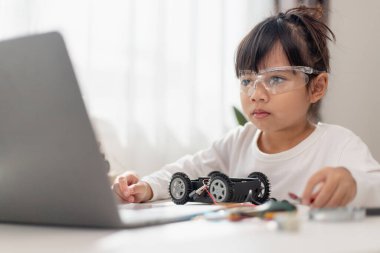 Asyalı öğrenciler evlerinde robot arabaları ve elektronik tahta kablolarını STEM, STEAM, matematik mühendisliği, bilim teknolojisi bilgisayar kodlarını çocuk konsepti için robotikte kodlayarak öğreniyorlar..