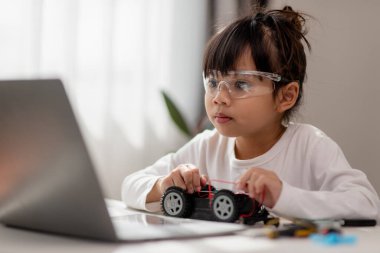 Asyalı öğrenciler evlerinde robot arabaları ve elektronik tahta kablolarını STEM, STEAM, matematik mühendisliği, bilim teknolojisi bilgisayar kodlarını çocuk konsepti için robotikte kodlayarak öğreniyorlar..