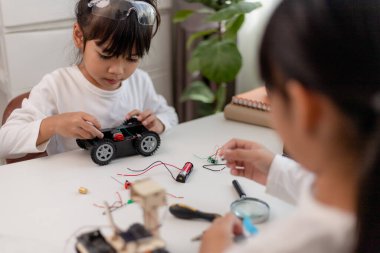 Asyalı öğrenciler evlerinde robot arabaları ve elektronik tahta kablolarını STEM, STEAM, matematik mühendisliği, bilim teknolojisi bilgisayar kodlarını çocuk konsepti için robotikte kodlayarak öğreniyorlar..