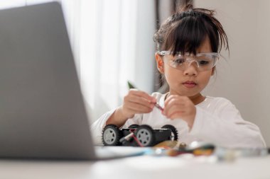 Asyalı öğrenciler evlerinde robot arabaları ve elektronik tahta kablolarını STEM, STEAM, matematik mühendisliği, bilim teknolojisi bilgisayar kodlarını çocuk konsepti için robotikte kodlayarak öğreniyorlar..