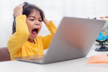 Asyalı çocuk evde online ders sırasında ödev öğrenme konusunda ciddidir, karantina sırasında sosyal mesafeler, kişisel izolasyon, çevrimiçi eğitim konsepti, evde eğitim, online video dersi hocası.