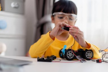 Asyalı öğrenciler evlerinde robot arabaları ve elektronik tahta kablolarını STEM, STEAM, matematik mühendisliği, bilim teknolojisi bilgisayar kodlarını çocuk konsepti için robotikte kodlayarak öğreniyorlar..
