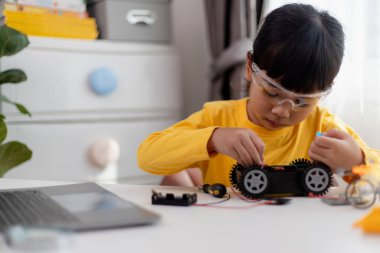 Asyalı öğrenciler evlerinde robot arabaları ve elektronik tahta kablolarını STEM, STEAM, matematik mühendisliği, bilim teknolojisi bilgisayar kodlarını çocuk konsepti için robotikte kodlayarak öğreniyorlar..
