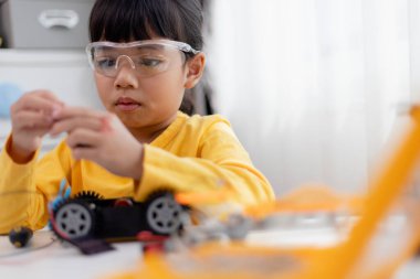 Asyalı öğrenciler evlerinde robot arabaları ve elektronik tahta kablolarını STEM, STEAM, matematik mühendisliği, bilim teknolojisi bilgisayar kodlarını çocuk konsepti için robotikte kodlayarak öğreniyorlar..