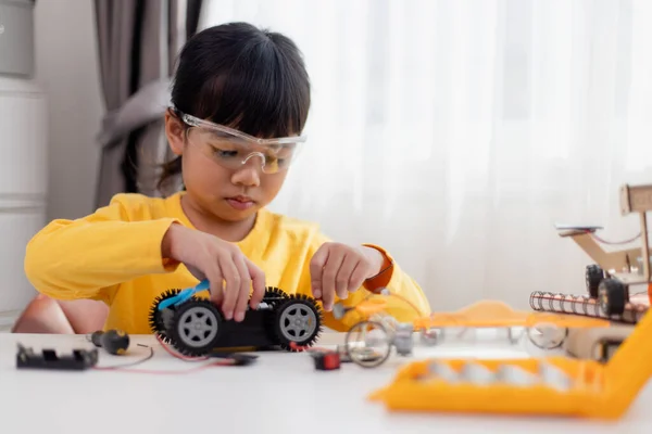 stock image Asia students learn at home in coding robot cars and electronic board cables in STEM, STEAM, mathematics engineering science technology computer code in robotics for kids concept.