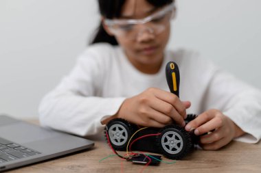 Asyalı öğrenciler evlerinde robot arabaları ve elektronik tahta kablolarını STEM, STEAM, matematik mühendisliği, bilim teknolojisi bilgisayar kodlarını çocuk konsepti için robotikte kodlayarak öğreniyorlar..