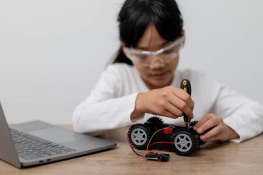 Asyalı öğrenciler evlerinde robot arabaları ve elektronik tahta kablolarını STEM, STEAM, matematik mühendisliği, bilim teknolojisi bilgisayar kodlarını çocuk konsepti için robotikte kodlayarak öğreniyorlar..