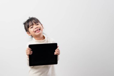 Asian little girl holding and using the digital tablet on white studio background, free copy space clipart