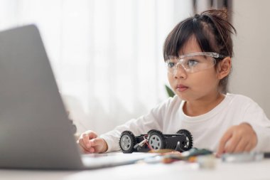 Asyalı öğrenciler evlerinde robot arabaları ve elektronik tahta kablolarını STEM, STEAM, matematik mühendisliği, bilim teknolojisi bilgisayar kodlarını çocuk konsepti için robotikte kodlayarak öğreniyorlar..