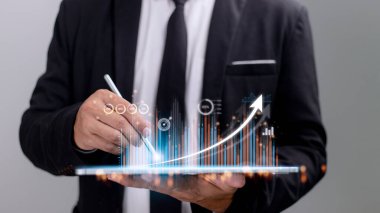 İnsanlar tablet kullanıyor ve sanal ekranda görünen bir iş grafiği ile parmaklarını ekranda kullanıyor. Yeni başlangıç fikirleri ve iş büyümesi kavramı..