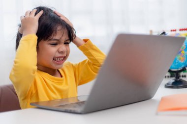 Asyalı çocuk evde online ders sırasında ödev öğrenme konusunda ciddidir, karantina sırasında sosyal mesafeler, kişisel izolasyon, çevrimiçi eğitim konsepti, evde eğitim, online video dersi hocası.