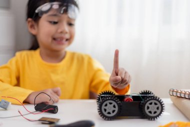 Asyalı öğrenciler evlerinde robot arabaları ve elektronik tahta kablolarını STEM, STEAM, matematik mühendisliği, bilim teknolojisi bilgisayar kodlarını çocuk konsepti için robotikte kodlayarak öğreniyorlar..