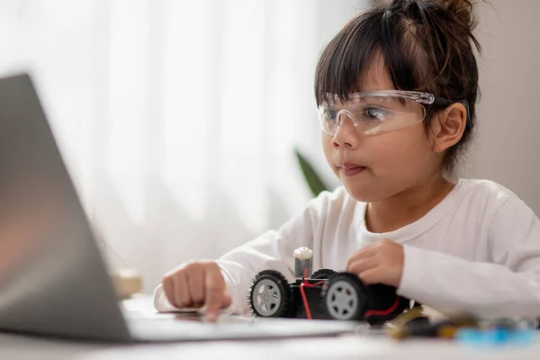 Stock image Asia students learn at home in coding robot cars and electronic board cables in STEM, STEAM, mathematics engineering science technology computer code in robotics for kids concept.