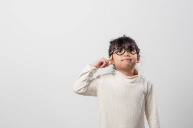 Asyalı küçük kız bir şey düşünüyor. Odak derinliği ve kopyalama alanı olan sığ alan seçin.