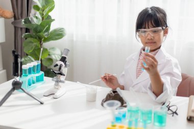 Asyalı liseli kız kolay kimya deneyleri yapıyor ve takipçileri için bir video kaydediyor, genç blogcu çocuk vlog için kamera önünde poz veriyor, çocuklar sosyal medya kanalı konsepti için vlog yapıyor.