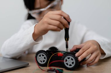 Asyalı öğrenciler evlerinde robot arabaları ve elektronik tahta kablolarını STEM, STEAM, matematik mühendisliği, bilim teknolojisi bilgisayar kodlarını çocuk konsepti için robotikte kodlayarak öğreniyorlar..