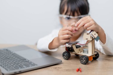 Asyalı öğrenciler evlerinde robot arabaları ve elektronik tahta kablolarını STEM, STEAM, matematik mühendisliği, bilim teknolojisi bilgisayar kodlarını çocuk konsepti için robotikte kodlayarak öğreniyorlar..