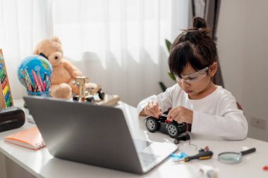 Asyalı öğrenciler evlerinde robot arabaları ve elektronik tahta kablolarını STEM, STEAM, matematik mühendisliği, bilim teknolojisi bilgisayar kodlarını çocuk konsepti için robotikte kodlayarak öğreniyorlar..