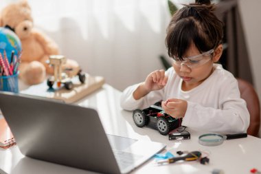 Asyalı öğrenciler evlerinde robot arabaları ve elektronik tahta kablolarını STEM, STEAM, matematik mühendisliği, bilim teknolojisi bilgisayar kodlarını çocuk konsepti için robotikte kodlayarak öğreniyorlar..
