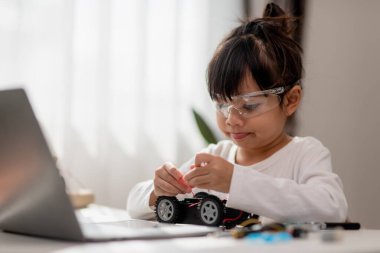 Asyalı öğrenciler evlerinde robot arabaları ve elektronik tahta kablolarını STEM, STEAM, matematik mühendisliği, bilim teknolojisi bilgisayar kodlarını çocuk konsepti için robotikte kodlayarak öğreniyorlar..