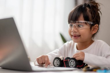 Asyalı öğrenciler evlerinde robot arabaları ve elektronik tahta kablolarını STEM, STEAM, matematik mühendisliği, bilim teknolojisi bilgisayar kodlarını çocuk konsepti için robotikte kodlayarak öğreniyorlar..