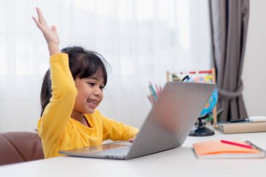 Okuldaki ilk günüm. Asyalı küçük kız dizüstü bilgisayar kullanıyor, online e-öğrenme sistemini inceliyor..