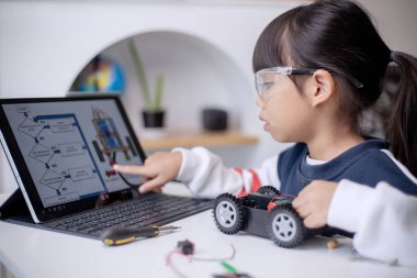 Asyalı öğrenciler evlerinde robot arabaları ve elektronik tahta kablolarını STEM, STEAM, matematik mühendisliği, bilim teknolojisi bilgisayar kodlarını çocuk konsepti için robotikte kodlayarak öğreniyorlar.