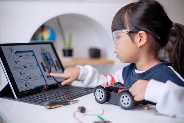 stock image Asia students learn at home in coding robot cars and electronic board cables in STEM, STEAM, mathematics engineering science technology computer code in robotics for kids concept